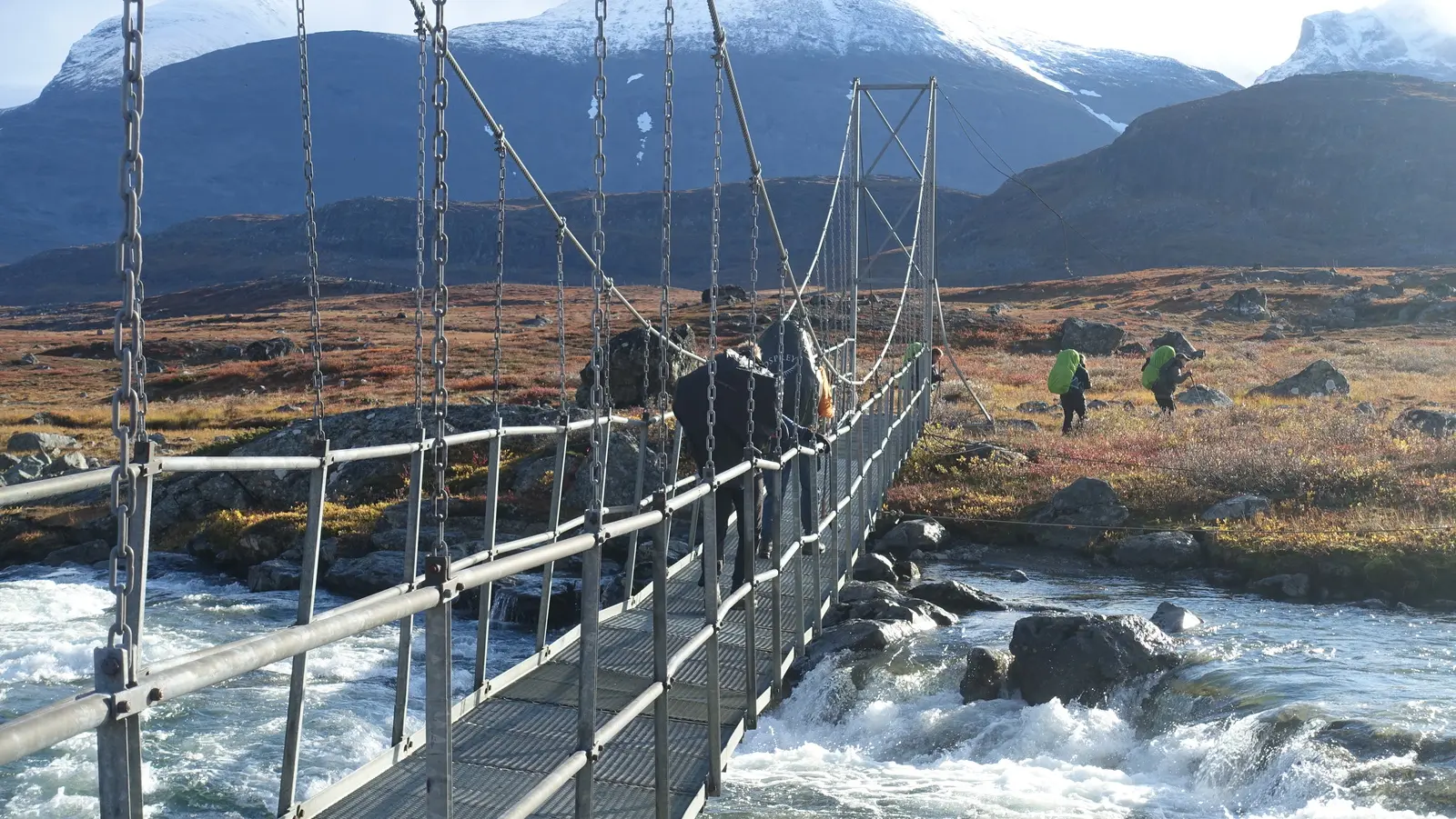 Den Guhkesvakkjahka-Fluss mit seiner starken Strömung queren Sie per Brücke