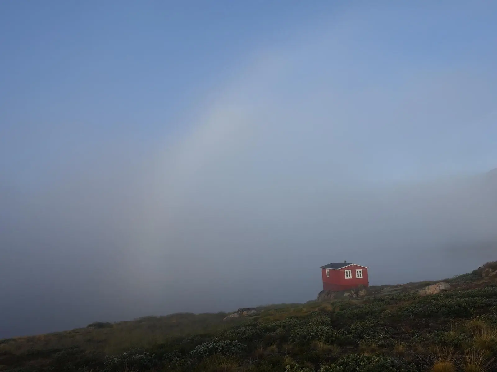 Die rote Innajuattoq-Hütte liegt malerisch am Seeufer.